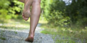 woman's feet running on gravel road
